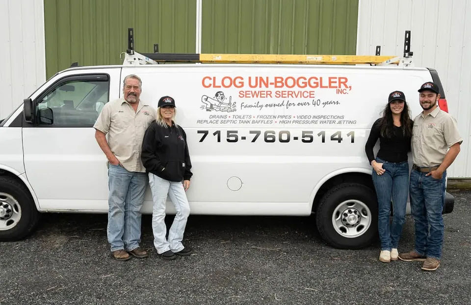 Brad, Lisa, Callie and Nathan standing beside the Clog Un-Boggler service van.